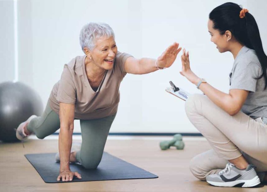 A physical therapist celebrating progress with a patient during a one-on-one session